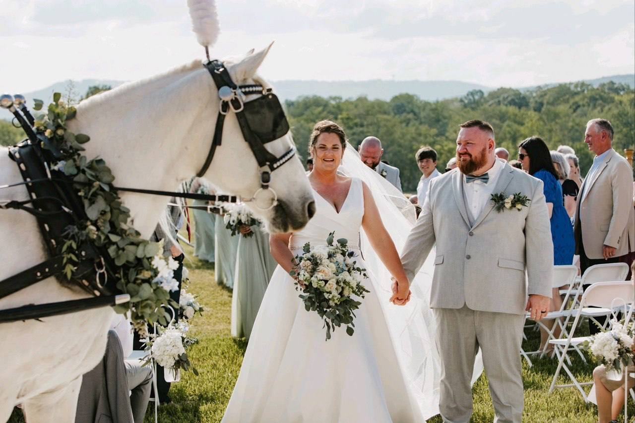 Bride and groom by elegant white carriage